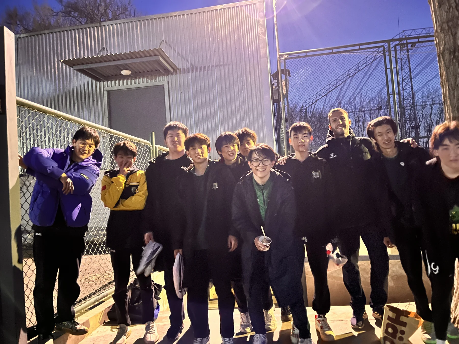 Kaize Zheng with teammates from Beijing Huijia High School beside the field